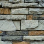 Close-up of a textured stone wall with a variety of natural colors.